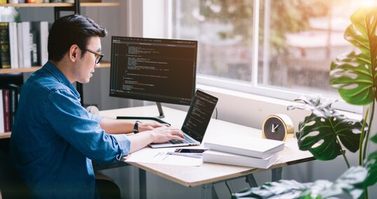 Young Asian programmer working at office