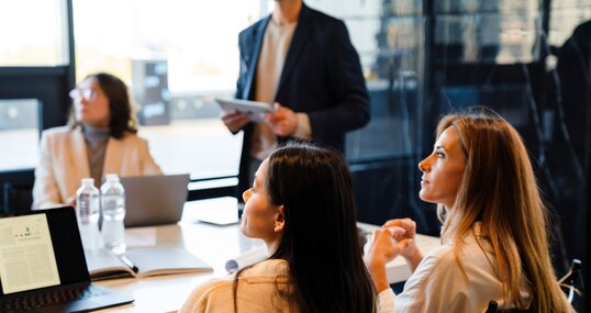 Different age colleagues examining presentation during offline meeting